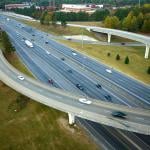 An aerial view of an American freeway intersection with fast moving trucks and cars.