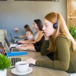 A row of female customer service representatives taking calls in their office.