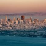 A foggy view of the San Francisco skyline during sunset.