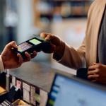 Person taps credit card on a payment terminal at a hotel.