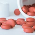 Ibuprofen tablets spilled from a bottle.