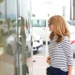 Woman facing a glass display while window shopping.