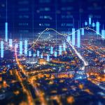Aerial view of a city at night illustrated with holographic finance charts.