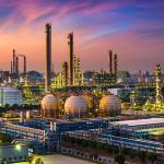 A view of a large industrial oil refinery and chemical plant during sunset.