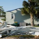 Debris on the side of a street after a hurricane in a residential area in Florida.
