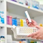 A pharmacist holding a basket to fill out a prescription.