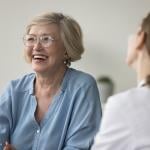 A senior woman laughing during clinic visit.