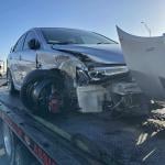 A crashed car loaded on a tow truck.
