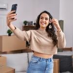 A young woman taking a selfie with her new home's keys.