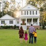 A family of four looking at their newly-constructed home.