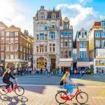People riding bicycles along Damrak street in central Amsterdam.