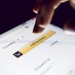 Person about to tap 'Add to basket' button on a shopping app.