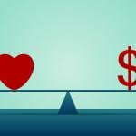 A heart and a dollar symbol on both ends of a seesaw.