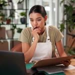 A female small flower business owner reviewing reports in the store.