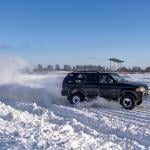 A 4x4 all-wheel drive-modified SUV on the road during heavy winter.