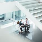 A doctor and administrators talking in a hospital lobby.