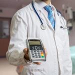 A doctor holding a payment terminal.