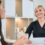 A young woman consulting with a dermatologist at the reception bar of a spa.