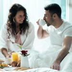 A young couple having breakfast in bed during their honeymoon.