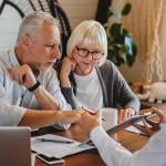 A senior couple consulting with a real estate professional.