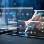AI workflow automation graphics over a person using a laptop and digital tablet at work.