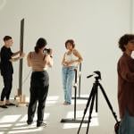 A creative team photographing a fashion model in a studio.