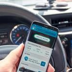 A 'find fuel near me' app displayed on a driver's smartphone while inside the car.