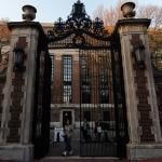 Students go in and out of the Harvard University gate.