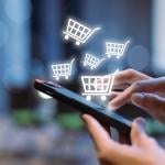 Shopping cart icons over a person using a shopping app on a smartphone.