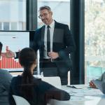 A CEO leading a business presentation in a boardroom.