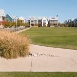 Grassy neighborhood park surrounded by modern homes and sidewalks in Oklahoma City.