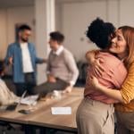 An office worker embracing a colleague. 