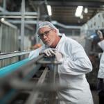 A focused factory engineer monitoring a production line.