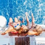 A group of happy friends seated by the platform of a yacht.