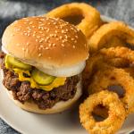 Homemade slug burgers with pickles and onion rings on the side.