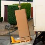 A large parcel box being loaded in a shipping truck.