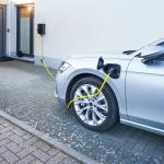 A car connected to an EV charger at home installed in the driveway.