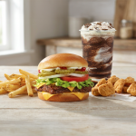 A burger meal with fries, chicken nuggets, and frosty drink.