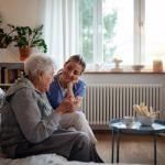 A senior woman accompanied by her caregiver at home.