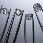 Close up of lab grown diamonds held by tweezers.