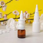 Nasal drops with medicine pills in the background.