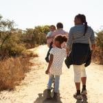 Grandparents walking outdoors with their grandchildren.