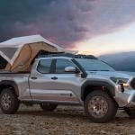 Silver 2023 Toyota Tacoma Truck with a tent built out for camping covering the truck bed. 