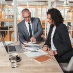 Two business executives reviewing a report.
