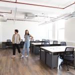Colleagues looking around an empty modern office for startup plans.
