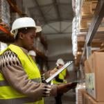 A worker doing a package inventory in a distribution warehouse.