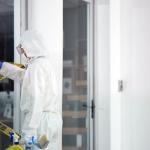 A forensic team removing a barrier tape from a crime scene.