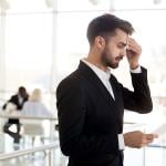 A business employee sweating and feeling nervous before speaking to an audience.