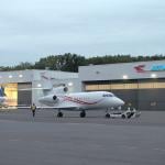 Line technicians working at the Teterboro Airport, operating aircraft towing vehicles and parking airplanes in the hangar.