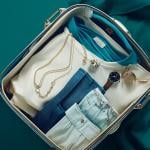 A travel bag with clothes and jewelry.